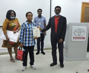 _Mr. B. Onafowokan presenting Certificate to Oluwatofarati Osunnubi, winner 1st Position 8-11 years category to the admiration of his parents